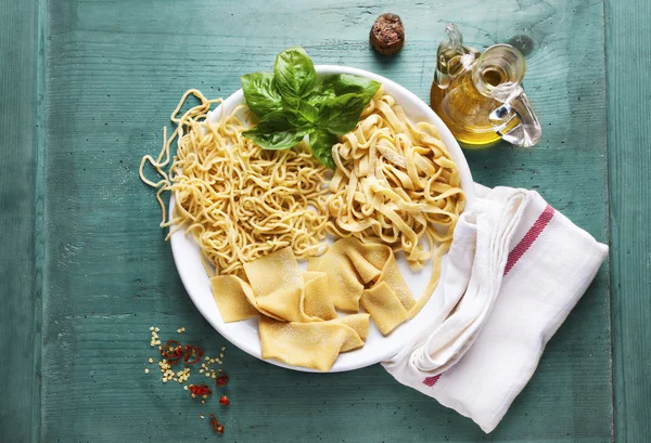 Various types of Homemade Fresh Pasta on the plate on a Emerald — Stock Photo, Image
