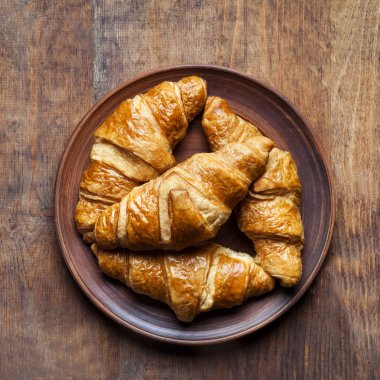 Kruvasan grup bir plaka üzerinde bir ahşap antika masa üzerinde.