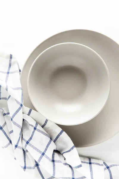 Set of empty plates on a white background and a kitchen towel — Stock Photo, Image