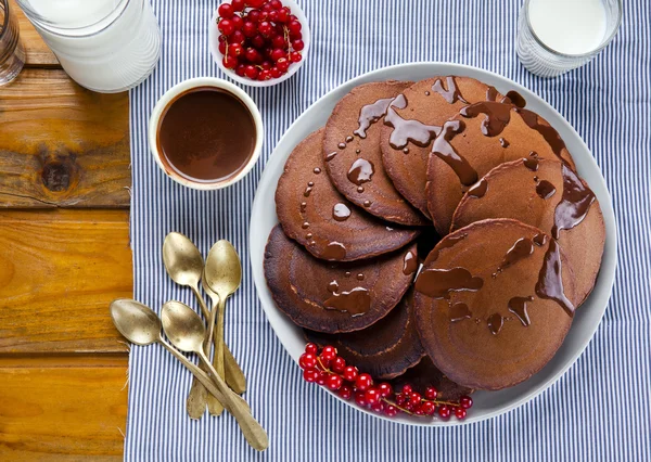 Schokoladen-Pfannkuchen mit Schokoladensirup auf einem Holztisch. reif — Stockfoto