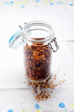 bir tabloda bir masa örtüsü ile hava geçirmez bir kavanoza granola