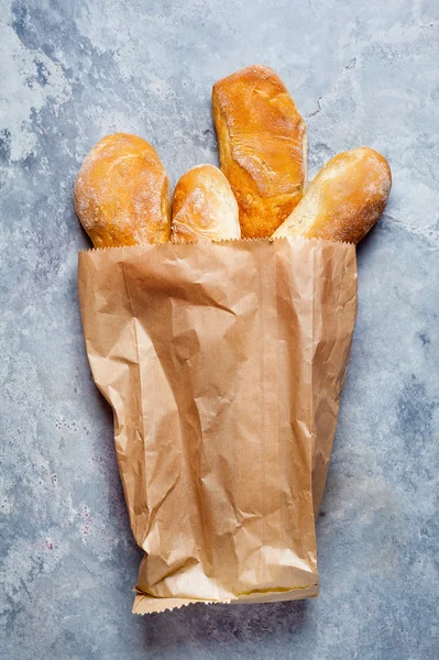 Pão em um saco de papel em um fundo de pedra cinza — Fotografia de Stock