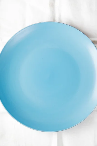 Empty blue dish on a white tablecloth — Stock Photo, Image