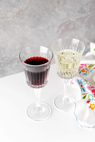 Red and white wine in glasses on a white table Stock Image