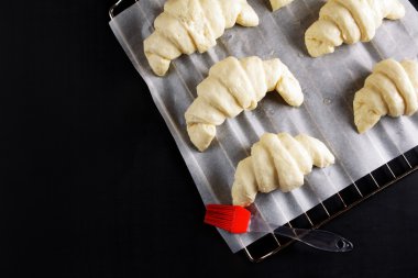 kruvasan pişirme için bir fırın tepsisine fırın için hazır. fırça 