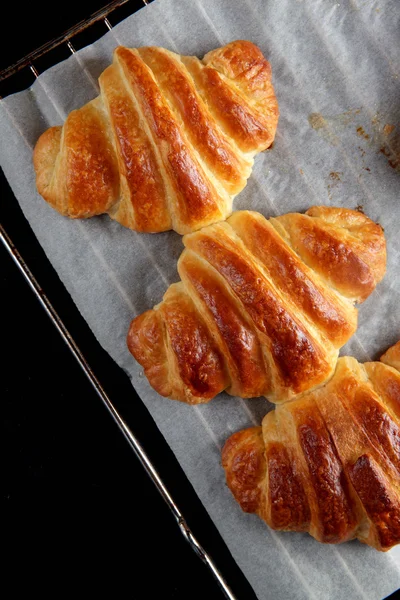 Baked croissants on a baking sheet. Healthy breakfast comfort — Stock Photo, Image