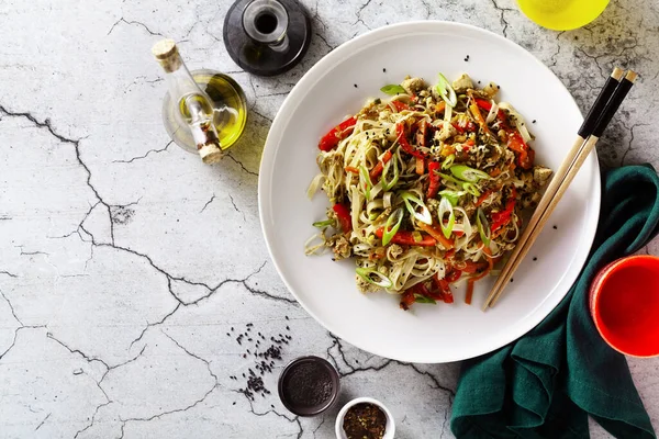 Sebzeli vejetaryen Tayland pirinçli makarna ve soya soslu gri beton arka planda tofu ve susam yağı.