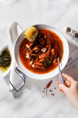 Mantarlı, beyaz fasulyeli ve mermer bir masada pampushki çörekli Ukrayna çorbası.