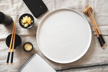 Suşi, Asya mutfağı teması ve konsepti olan boş yemek arkaplanı. Yemek çubuğu ve akıllı telefon.