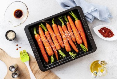 Masanın üzerinde susam tohumları ve soya sosuyla pişirilmiş taze havuçlar. bahar tarifi