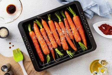 Masanın üzerinde susam tohumları ve soya sosuyla pişirilmiş taze havuçlar. bahar tarifi