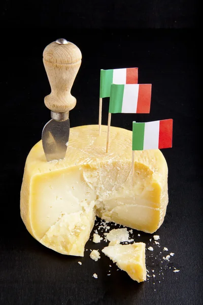 Hela parmesan med handtag ost kniv & italiensk flagg. på bl — Stockfoto
