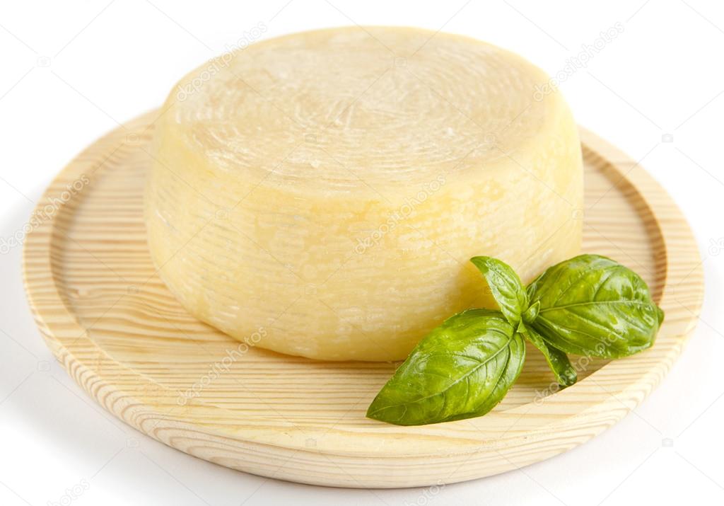 whole form of cheese parmesan. with fresh basil. on wooden plate