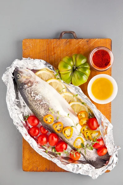 Сира риба з овочами на дерев'яній дошці — стокове фото
