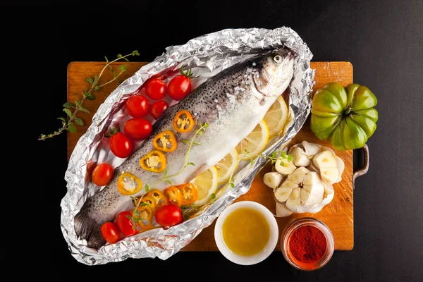 Сира риба з овочами на дерев'яній дошці — стокове фото