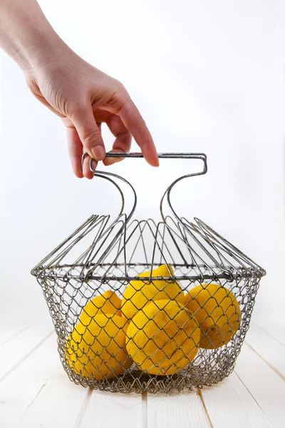 Лимоны в корзине в руке — стоковое фото