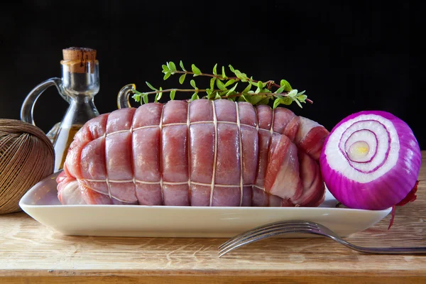 Carne assada crua pronta para ser colocada no forno. com cebola vermelha e o — Fotografia de Stock