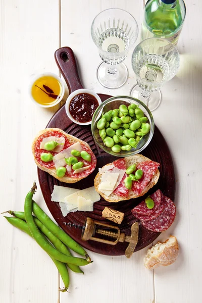Italian snacks. salami sandwich with parmesan cheese & broad bea — Stock Photo, Image