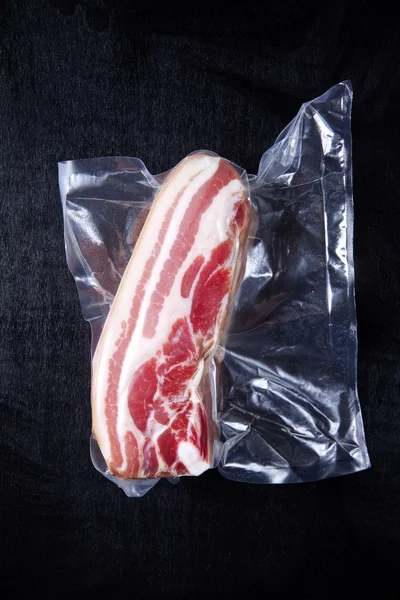 Bacon cru em preto — Fotografia de Stock