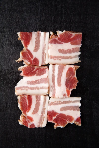 Bacon cru em preto — Fotografia de Stock