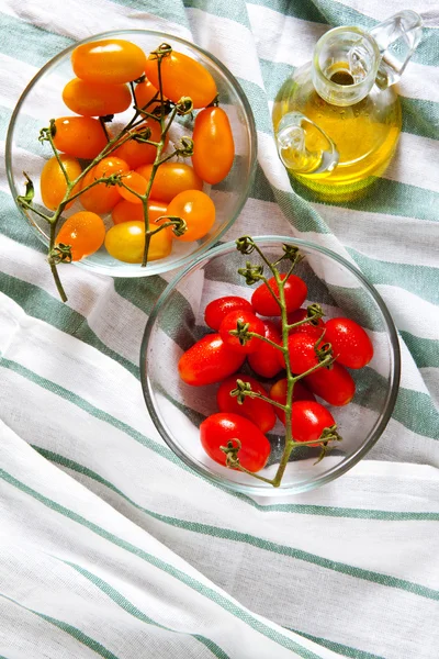 Tomates cherry rojos y amarillos sicilianos en tazón de cristal en servilleta —  Fotos de Stock