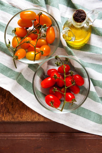 Tomates cherry rojos y amarillos sicilianos en tazón de cristal en servilleta —  Fotos de Stock