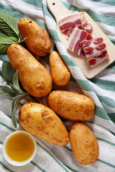 Patate e pancetta affettata sul vecchio fondo in legno. salvia & o — Foto Stock