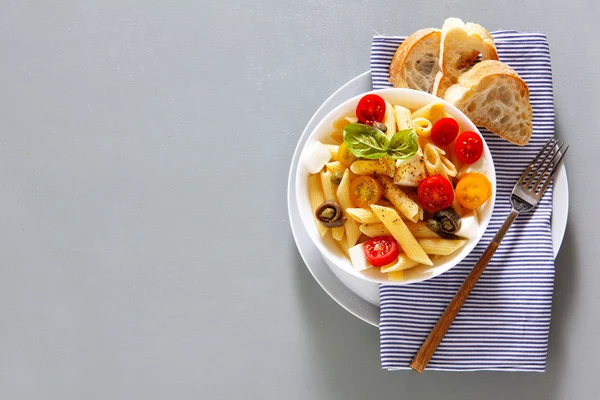 Healthy summer light pasta salad with fresh raw tomatoes, anchov