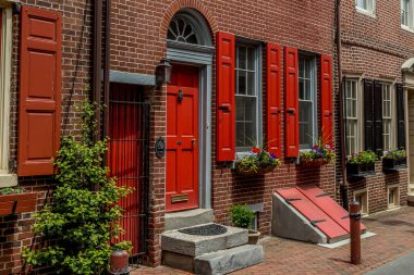 Philadelphia 'nın ünlü Elfreth' s Alley 'si Philadelphia' nın eski şehir bölümünde, parke taşı sokağındaki renkli koloni evleri. Lamba direkleri, çiçekler ve bağlama direkleri tuğla yürüyüş yolunu vurguluyor. 