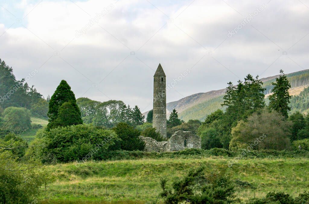 Ireland Glendalough Monastic site as seen at a distance.  Irelands mountains and forest surround the famous round tower. 