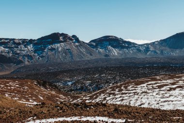 Karla kaplı dağlarla çevrili bir volkan vadisi.