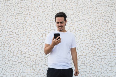 Beyaz arka planda duygularını ifade eden bıyıklı ve beyaz gömlekli bir çocuk.