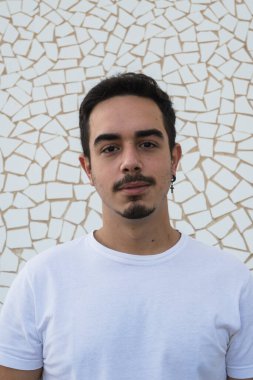 Beyaz arka planda duygularını ifade eden bıyıklı ve beyaz gömlekli bir çocuk.