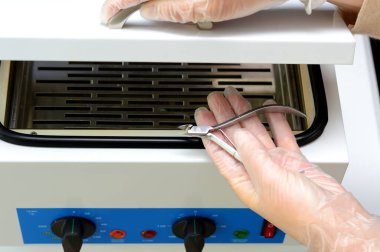 Manikür forseps ile eldivenli el, buhar sterilizasyonu için aletler hazırlama, kuru sıcak hava sterilizatöründeki bakteri ve viral enfeksiyonlardan dezenfekte etme, otomatik klavye