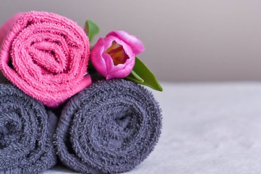 Pembe lale çiçekli rulo şeklinde temiz havlular.