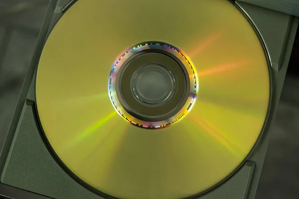 Oynatıcının açık tepsisindeki altın DVD kompakt diskin üst görünümü.