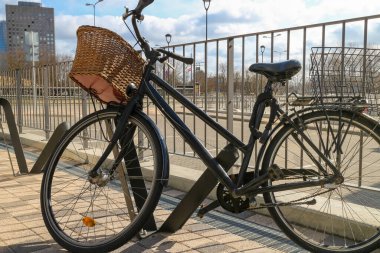 Bakkal sepetli bisiklet, bisikletli bir park yerinde park edilmiştir. Şehirde bisiklete binmek ve bisiklet sürmek. Market alışverişi ve bisikletle eve teslimat..