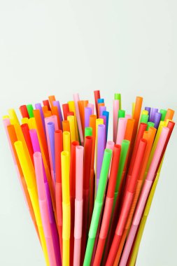 Beyaz arka planda tek kullanımlık plastik pipetler. Bir kokteyl ve içki partisi için renkli aksesuar ve dekorasyon..