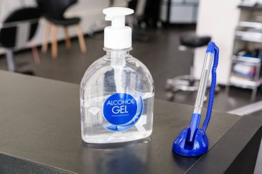 Alkol jeli ve el dezenfeksiyonu için salondaki resepsiyonda. Ziyaretçiler ve salon müşterileri için bir kalem..