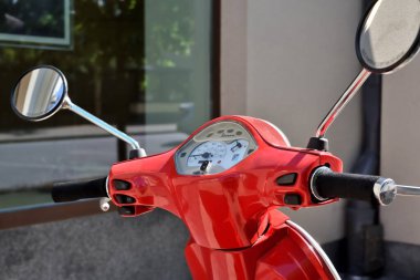Gösterge paneli ve dikiz aynalı mobilet gidonu. Klasik klasik kırmızı motor scooter tasarımı.