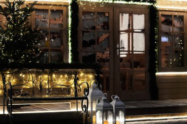 Evin girişi festival süslemeleri, ışık çelenkleri ve tatil gecelerinde bir Noel ağacı ile süslenir. Yılbaşı arifesinde bayram havası. Noel ışıkları olan dekore edilmiş bir ev..