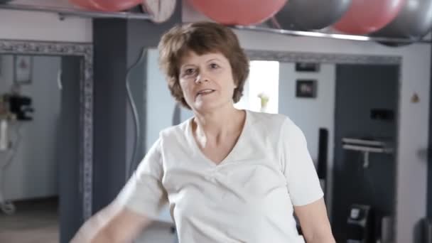 Äldre kvinna sträcker ut i fitness rum, mogen, motion, yoga — Stockvideo