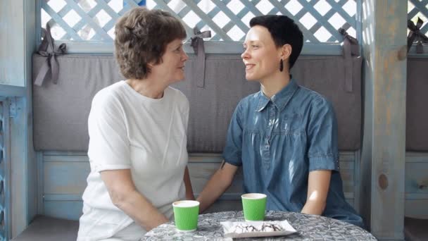 Mère aînée et jeune fille parlent sur le canapé, souriant et étreignant. Famille heureuse . — Video