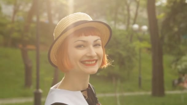 Krásná červená hlava mladá žena fouká polibek, usmívající se, flirtování. Atraktivní a veselá dívka pin-up ve stylu retro šaty a klobouk. Pozitivní emoce. Šťastné a veselé. Západ slunce. — Stock video