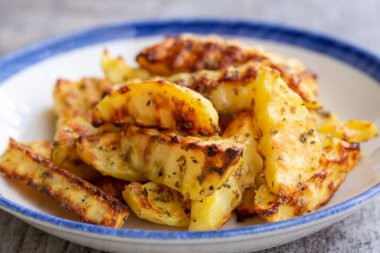 Baharat ve otlarla fırın fırınında pişirilmiş dalgalı patatesleri yakından izleyin.