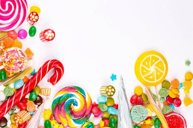 Renkli lolipoplar ve farklı renkte yuvarlak şekerler. Üst görünüm.