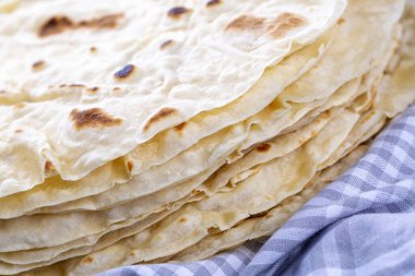 Mavi ve beyaz kareli kumaş üzerinde ev yapımı pide ekmeği