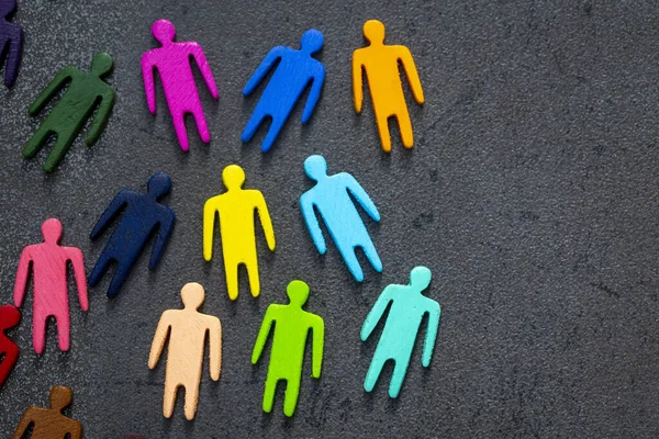 Equality and diversity concept. Multi-colored wooden figurines on a blackboard.