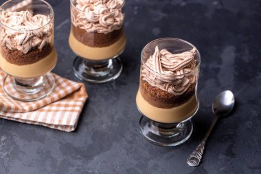 Klasik tiramisu tatlısı, çikolata ve krem şantili koyu bir arka plan.