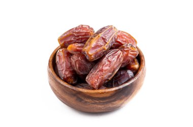 Beyaz arka planda izole edilmiş bir kasede kurumuş tarihler.